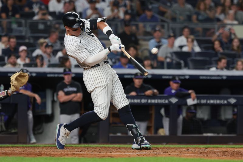 Aug 23, 2024; Bronx, New York, USA;  New York Yankees center fielder Aaron Judge (99) hits a solo home run during the sixth inning against the Colorado Rockies at Yankee Stadium. Mandatory Credit: Vincent Carchietta-USA TODAY Sports