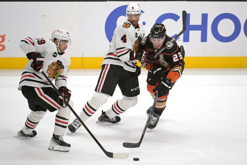 Mar 21, 2024; Anaheim, California, USA; Chicago Blackhawks center Andreas Athanasiou (89), defenseman Seth Jones (4) and Anaheim Ducks center Mason McTavish (23) go for the puck in the first period at Honda Center. Mandatory Credit: Jayne Kamin-Oncea-USA TODAY Sports