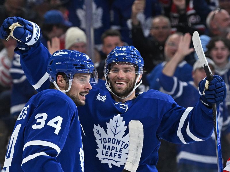 Oct 13, 2025; Toronto, Ontario, CAN; Toronto Maple Leafs right wing Calle Jarnkrok (19) celebrates a goal with Toronto Maple Leafs center Auston Matthews (34) in the third period at Scotiabank Arena. Mandatory Credit: Gerry Angus-Imagn Images