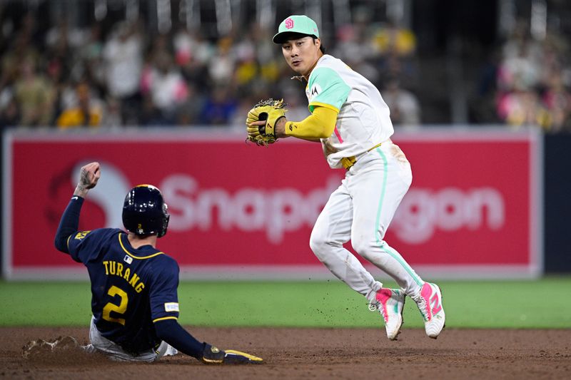 Jun 21, 2024; San Diego, California, USA; San Diego Padres shortstop Ha-Seong Kim (7) throws to first base after forcing out Milwaukee Brewers second baseman Brice Turang (2) at second base to complete a double play during the eighth inning at Petco Park. Mandatory Credit: Orlando Ramirez-USA TODAY Sports