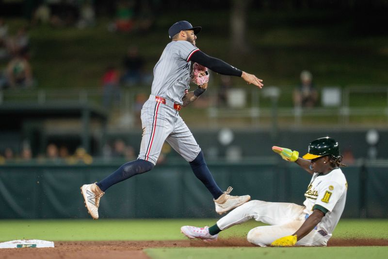 Jun 2, 2025; West Sacramento, California, USA; Minnesota Twins shortstop Carlos Correa (4) completes the double play while Athletics right fielder Lawrence Butler (4) slides into second base during the ninth inning at Sutter Health Park. Mandatory Credit: Neville E. Guard-Imagn Images