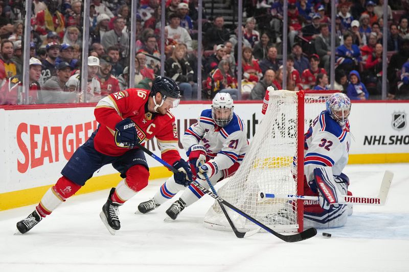 Dec 29, 2023; Sunrise, Florida, USA; Florida Panthers center Aleksander Barkov (16) passes the puck away from New York Rangers center Barclay Goodrow (21) and goaltender Jonathan Quick (32) during the second period at Amerant Bank Arena. Mandatory Credit: Jasen Vinlove-USA TODAY Sports