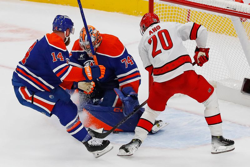 Oct 22, 2024; Edmonton, Alberta, CAN; Edmonton Oilers goaltender Stuart Skinner (74) makes a save on Carolina Hurricanes forward Sebastian Aho (20) during overtime at Rogers Place. Mandatory Credit: Perry Nelson-Imagn Images