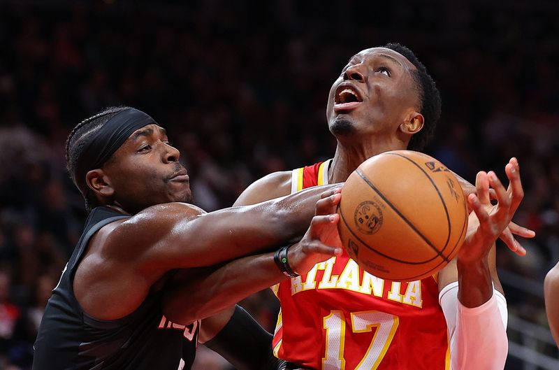 ATLANTA, GEORGIA - FEBRUARY 10:  Onyeka Okongwu #17 of the Atlanta Hawks draws a foul from Aaron Holiday #0 of the Houston Rockets during the second quarter at State Farm Arena on February 10, 2024 in Atlanta, Georgia.  NOTE TO USER: User expressly acknowledges and agrees that, by downloading and/or using this photograph, user is consenting to the terms and conditions of the Getty Images License Agreement.  (Photo by Kevin C. Cox/Getty Images)