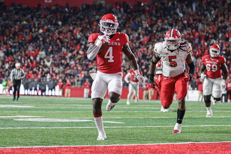 Nov 25, 2023; Piscataway, New Jersey, USA; Rutgers Scarlet Knights running back Aaron Young (4) scores a rushing touchdown as Maryland Terrapins defensive lineman Quashon Fuller (5) pursues during the first half at SHI Stadium. Mandatory Credit: Vincent Carchietta-USA TODAY Sports