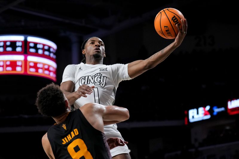 Jan 18, 2025; Cincinnati, Ohio, USA;  Cincinnati Bearcats guard Day Day Thomas (1) drives to the basket against Arizona State Sun Devils forward Basheer Jihad (8) in the first half at Fifth Third Arena. Mandatory Credit: Aaron Doster-Imagn Images
