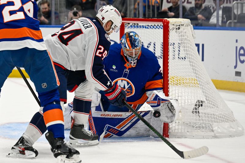 Nov 2, 2025; Elmont, New York, USA;  New York Islanders goaltender David Rittich (33) makes a save on Columbus Blue Jackets right wing Mathieu Olivier (24) during the second period at UBS Arena. Mandatory Credit: Dennis Schneidler-Imagn Images