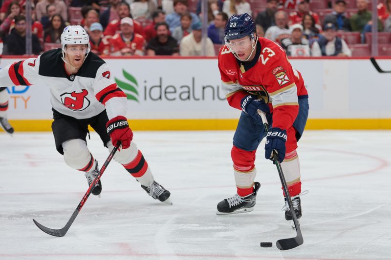 Nov 20, 2025; Sunrise, Florida, USA; Florida Panthers center Carter Verhaeghe (23) moves the puck against New Jersey Devils defenseman Dougie Hamilton (7) during the second period at Amerant Bank Arena. Mandatory Credit: Sam Navarro-Imagn Images