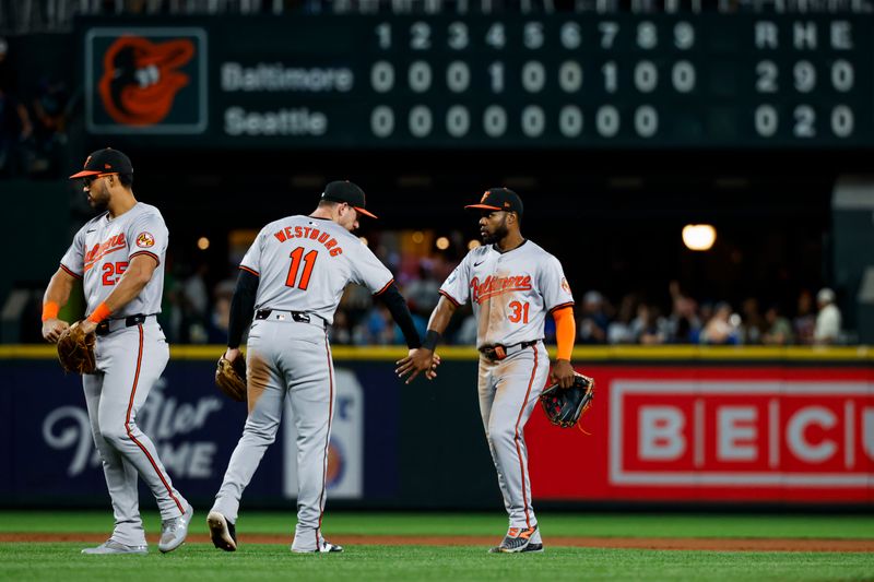 Jul 2, 2024; Seattle, Washington, USA; Baltimore Orioles third baseman Jordan Westburg (11) and center fielder Cedric Mullins (31) celebrate following a 2-0 victory against the Seattle Mariners at T-Mobile Park. Mandatory Credit: Joe Nicholson-USA TODAY Sports