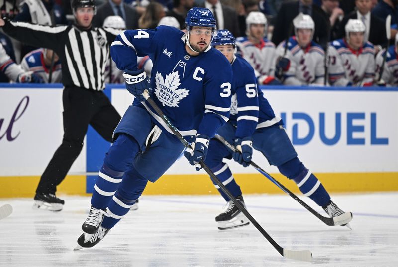 Oct 16, 2025; Toronto, Ontario, CAN;  Toronto Maple Leafs forward Auston Matthews (34) skates up the ice followed by forward Easton Cowan (53) in the first period at Scotiabank Arena. Mandatory Credit: Dan Hamilton-Imagn Images