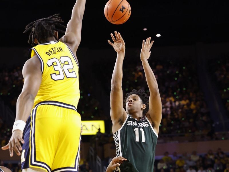 Feb 18, 2023; Ann Arbor, Michigan, USA;  Michigan State Spartans guard A.J. Hoggard (11) shoots the ball against Michigan Wolverines forward Tarris Reed Jr. (32) in the second half at Crisler Center. Mandatory Credit: Rick Osentoski-USA TODAY Sports