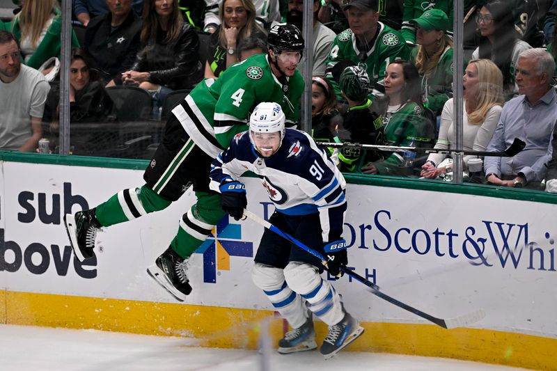 May 17, 2025; Dallas, Texas, USA; Dallas Stars defenseman Miro Heiskanen (4) and Winnipeg Jets center Cole Perfetti (91) crash into the boards during the third period in game six of the second round of the 2025 Stanley Cup Playoffs at American Airlines Center. Mandatory Credit: Jerome Miron-Imagn Images