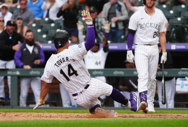 Apr 25, 2024; Denver, Colorado, USA; Colorado Rockies shortstop Ezequiel Tovar (14) scores on a wild pitch in the eighth inning against the San Diego Padres at Coors Field. Mandatory Credit: Ron Chenoy-USA TODAY Sports