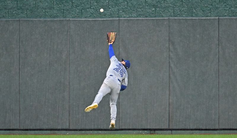 Apr 25, 2024; Kansas City, Missouri, USA;  Toronto Blue Jays center fielder Daulton Varsho (25) makes a leaping effort on a triple hit by Kansas City Royals Kyle Isbel (not pictured) in the fifth inning at Kauffman Stadium. Mandatory Credit: Peter Aiken-USA TODAY Sports