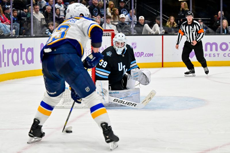 Jan 18, 2025; Salt Lake City, Utah, USA; St. Louis Blues left wing Jake Neighbours (63) fakes Utah Hockey Club goalie Connor Ingram (39) during third period at the Delta Center. Mandatory Credit: Christopher Creveling-Imagn Images