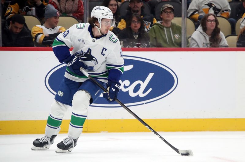 Nov 27, 2024; Pittsburgh, Pennsylvania, USA;  Vancouver Canucks defenseman Quinn Hughes (43) handles the puck against the Pittsburgh Penguins during the third period at PPG Paints Arena. Mandatory Credit: Charles LeClaire-Imagn Images