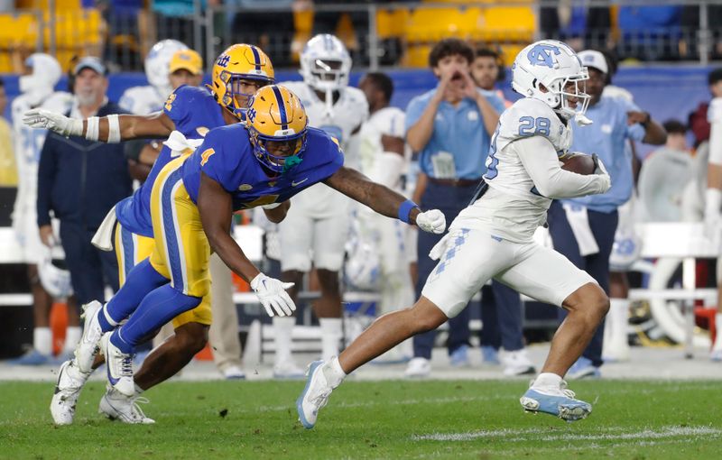 Sep 23, 2023; Pittsburgh, Pennsylvania, USA; North Carolina Tar Heels defensive back Alijah Huzzie (28) runs on his way to scoring on a fifty-two yard punt return against the Pittsburgh Panthers during the second quarter at Acrisure Stadium. Mandatory Credit: Charles LeClaire-USA TODAY Sports