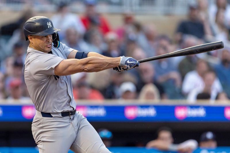 May 14, 2024; Minneapolis, Minnesota, USA; New York Yankees designated hitter Giancarlo Stanton (27) hits a single against the Minnesota Twins in the fourth inning at Target Field. Mandatory Credit: Jesse Johnson-USA TODAY Sports