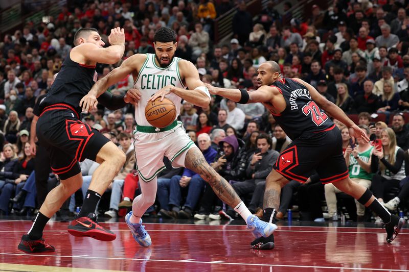 CHICAGO, ILLINOIS - NOVEMBER 29: Jayson Tatum #0 of the Boston Celtics dribbles the ball between Nikola Vucevic #9 and Talen Horton-Tucker #22 of the Chicago Bulls during the second quarter of the Emirates NBA Cup game at the United Center on November 29, 2024 in Chicago, Illinois. NOTE TO USER: User expressly acknowledges and agrees that, by downloading and or using this photograph, User is consenting to the terms and conditions of the Getty Images License Agreement.  (Photo by Luke Hales/Getty Images)