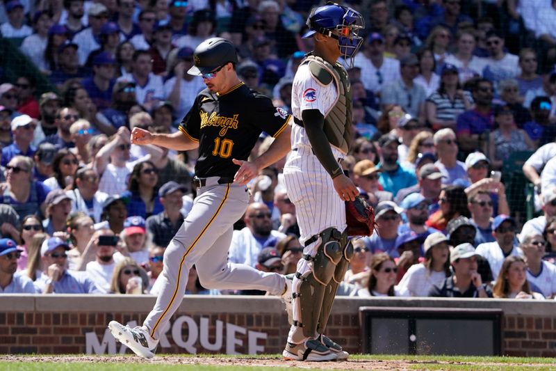 May 19, 2024; Chicago, Illinois, USA; Pittsburgh Pirates outfielder Bryan Reynolds (10) scores as Chicago Cubs catcher Miguel Amaya (9) stands nearby during the fifth inning at Wrigley Field. Mandatory Credit: David Banks-USA TODAY Sports