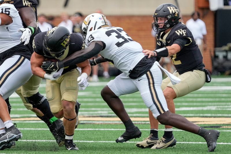 Sep 9, 2023; Winston-Salem, North Carolina, USA; Wake Forest Demon Deacons running back Tate Carney (30) is tackled by Vanderbilt Commodores defensive back BJ Diakite (33) during the second quarter at Allegacy Federal Credit Union Stadium. Mandatory Credit: Jim Dedmon-USA TODAY Sports