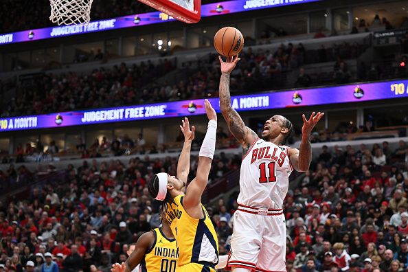 CHICAGO, ILLINOIS - DECEMBER 28:  DeMar DeRozan #11 of the Chicago Bulls shoots from the baseline for two points as Andrew Nembhard #2 of the Indiana Pacers defends in the second half on December 28, 2023 at the United Center in Chicago, Illinois. Indiana defeated Chicago 120-104.   NOTE TO USER: User expressly acknowledges and agrees that, by downloading and or using this photograph, User is consenting to the terms and conditions of the Getty Images License Agreement.  (Photo by Jamie Sabau/Getty Images)