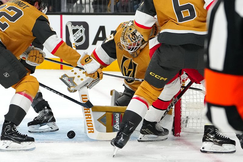 Nov 11, 2024; Las Vegas, Nevada, USA; Vegas Golden Knights goaltender Adin Hill (33) makes a save against the Carolina Hurricanes during the first period at T-Mobile Arena. Mandatory Credit: Stephen R. Sylvanie-Imagn Images