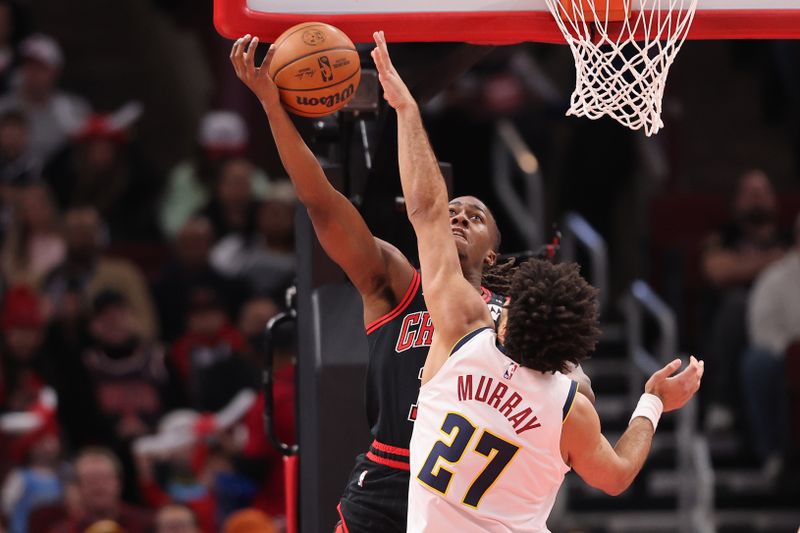 CHICAGO, ILLINOIS - JANUARY 27: Ayo Dosunmu #11 of the Chicago Bulls has his shot blocked by Jamal Murray #27 of the Denver Nuggets during the first half at the United Center on January 27, 2025 in Chicago, Illinois. NOTE TO USER: User expressly acknowledges and agrees that, by downloading and or using this photograph, User is consenting to the terms and conditions of the Getty Images License Agreement.  (Photo by Michael Reaves/Getty Images)