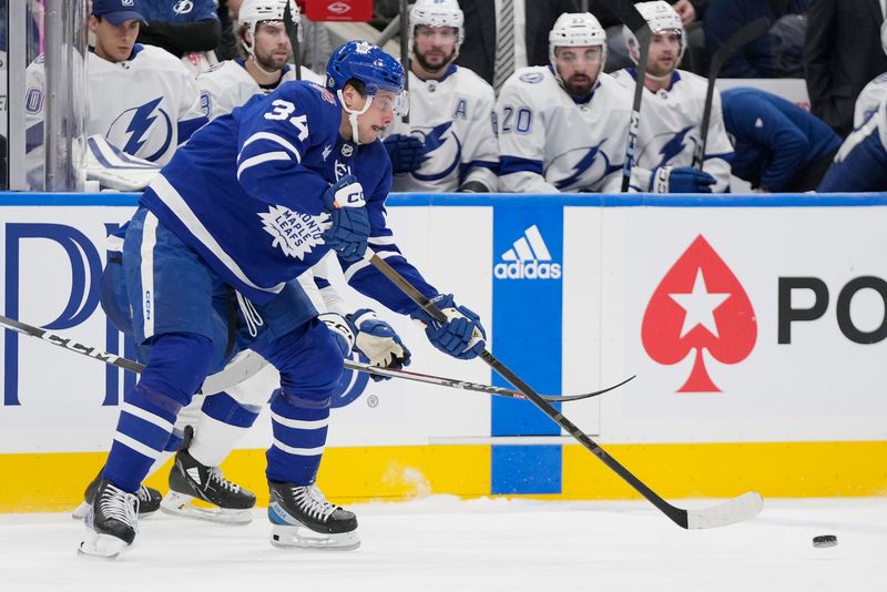 Nov 6, 2023; Toronto, Ontario, CAN; Toronto Maple Leafs forward Auston Matthews (34) passes the puck against the Tampa Bay Lightning during the second period at Scotiabank Arena. Mandatory Credit: John E. Sokolowski-USA TODAY Sports