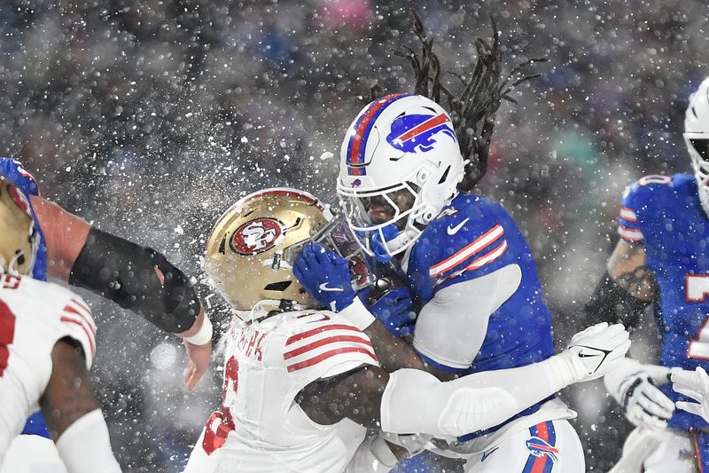 Buffalo Bills running back James Cook, middle right, is hit by San Francisco 49ers safety Malik Mustapha during the first half of an NFL football game in Orchard Park, N.Y., Sunday, Dec. 1, 2024. (AP Photo/Adrian Kraus)