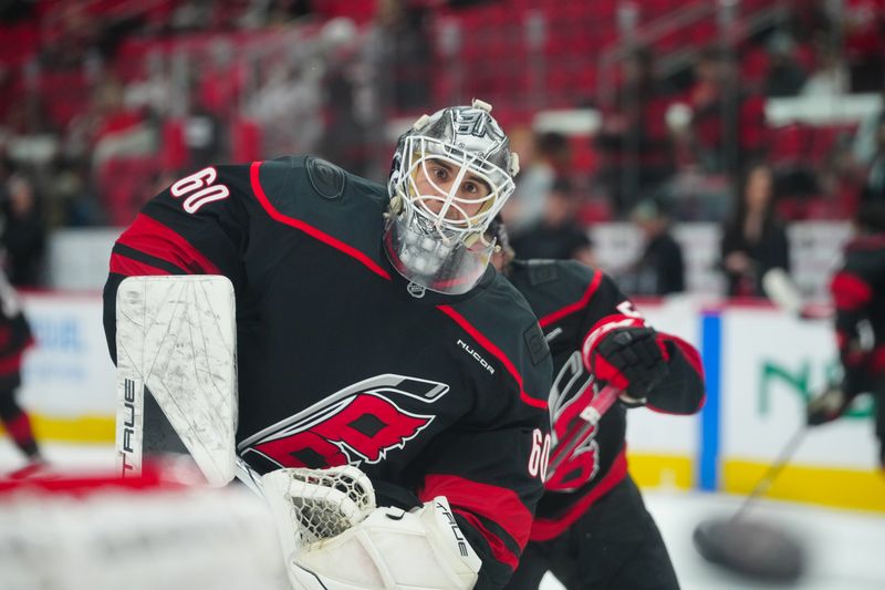 Nov 16, 2024; Raleigh, North Carolina, USA;  Carolina Hurricanes goaltender Yaniv Perets (60) shoots the puck  during the warmups before the game against the Ottawa Senators at Lenovo Center. Mandatory Credit: James Guillory-Imagn Images