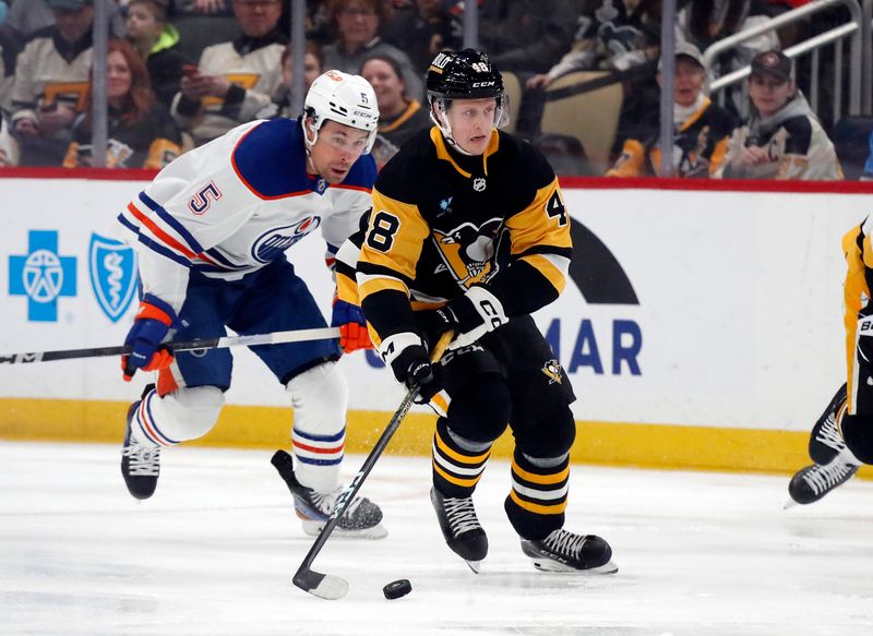 Mar 10, 2024; Pittsburgh, Pennsylvania, USA;  Pittsburgh Penguins right wing Valtteri Puustinen (48) moves the puck ahead of Edmonton Oilers defenseman Cody Ceci (5) during the first period at PPG Paints Arena. Mandatory Credit: Charles LeClaire-USA TODAY Sports