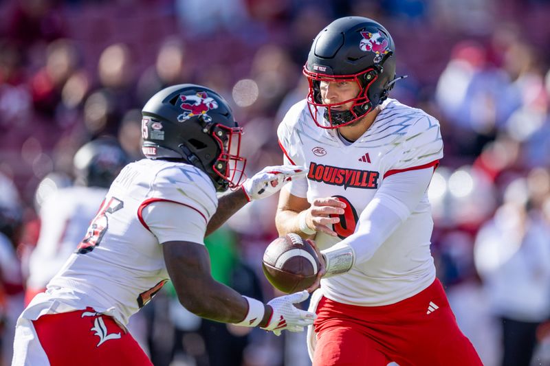 Nov 16, 2024; Stanford, California, USA;  Louisville Cardinals quarterback Tyler Shough (9) hands the ball to running back Isaac Brown (25) during the first quarter against the Stanford Cardinal at Stanford Stadium. Mandatory Credit: Bob Kupbens-Imagn Images