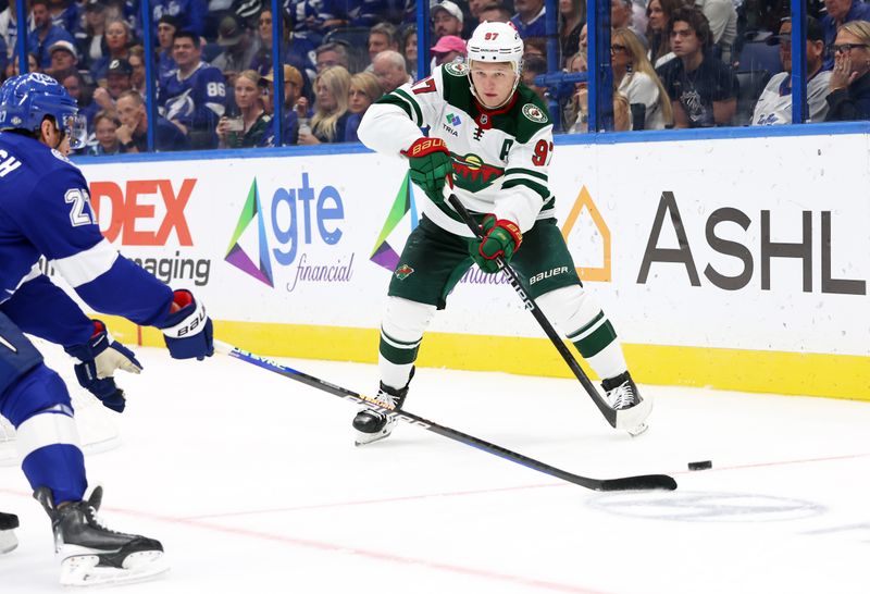 Oct 24, 2024; Tampa, Florida, USA; Minnesota Wild left wing Kirill Kaprizov (97) passes the puck as Tampa Bay Lightning defenseman Ryan McDonagh (27) defends during the second period at Amalie Arena. Mandatory Credit: Kim Klement Neitzel-Imagn Images