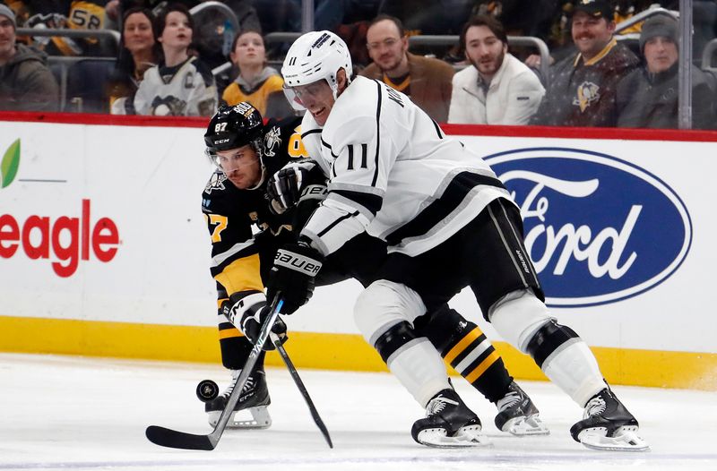 Feb 18, 2024; Pittsburgh, Pennsylvania, USA;  Los Angeles Kings center Anze Kopitar (11) moves the puck against Pittsburgh Penguins center Sidney Crosby (87) during the first period at PPG Paints Arena. Mandatory Credit: Charles LeClaire-USA TODAY Sports