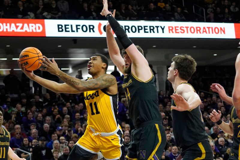 Mar 2, 2024; Evanston, Illinois, USA; Northwestern Wildcats center Matthew Nicholson (34) defends Iowa Hawkeyes guard Tony Perkins (11) during the first half at Welsh-Ryan Arena. Mandatory Credit: David Banks-USA TODAY Sports