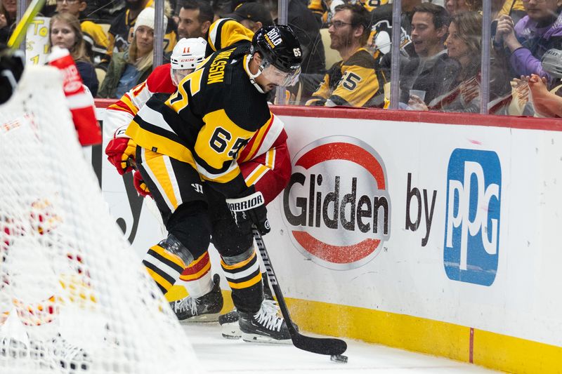 Oct 14, 2023; Pittsburgh, Pennsylvania, USA; Pittsburgh Penguins defenseman Erik Karlsson (65) skates the puck away from Calgary Flames center Mikael Backlund (11) during the second period at PPG Paints Arena. Mandatory Credit: Scott Galvin-USA TODAY Sports