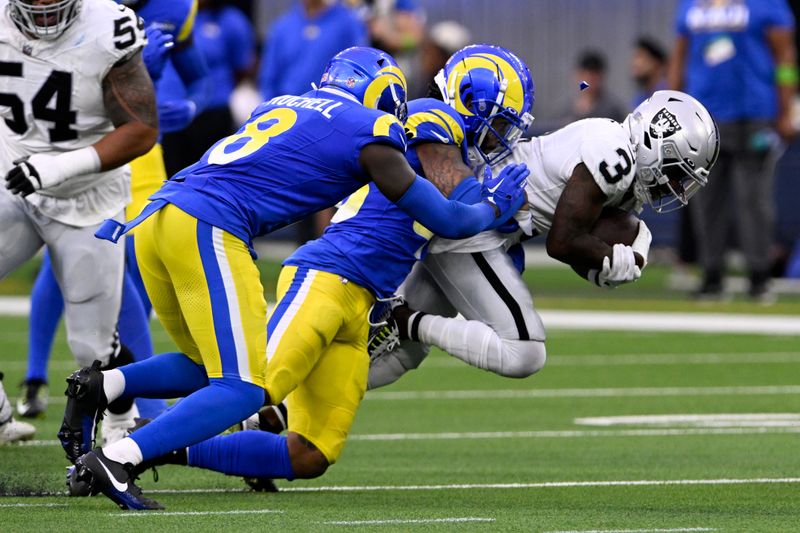 Las Vegas Raiders wide receiver DeAndre Carter (3) gets brought down by Los Angeles Rams linebacker Jaiden Woodbey, center, and cornerback Robert Rochell (8) during the first half of a preseason NFL football game Saturday, Aug. 19, 2023, in Inglewood, Calif. (AP Photo/Alex Gallardo)