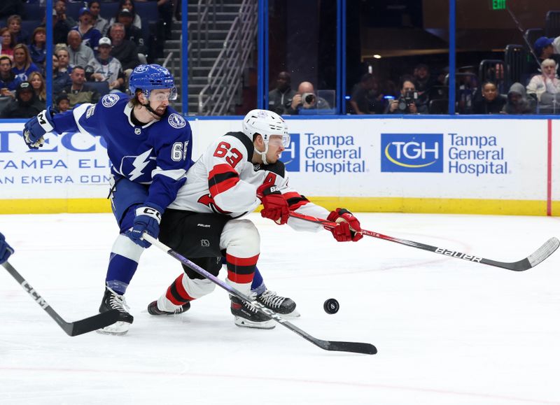 Jan 27, 2024; Tampa, Florida, USA; Tampa Bay Lightning defenseman Maxwell Crozier (65) defends New Jersey Devils left wing Jesper Bratt (63) during the second period at Amalie Arena. Mandatory Credit: Kim Klement Neitzel-USA TODAY Sports