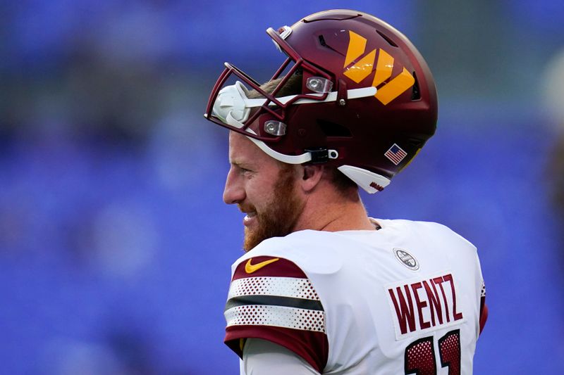 Washington Commanders quarterback Carson Wentz walks on the field before a preseason NFL football game against the Baltimore Ravens, Saturday, Aug. 27, 2022, in Baltimore. (AP Photo/Julio Cortez)