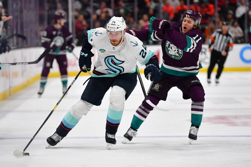 Dec 23, 2023; Anaheim, California, USA; Seattle Kraken defenseman Jamie Oleksiak (24) moves the puck ahead of Anaheim Ducks center Trevor Zegras (11) during the third period at Honda Center. Mandatory Credit: Gary A. Vasquez-USA TODAY Sports