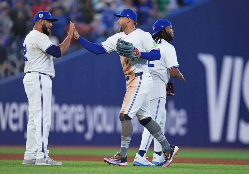 Apr 15, 2024; Toronto, Ontario, CAN; Toronto Blue Jays outfielder George Springer celebrates the win with relief pitcher Yimi Garcia all wearing number 42 for Jackie Robinson Day at the end of the ninth inning against the New York Yankees at Rogers Centre. Mandatory Credit: Nick Turchiaro-USA TODAY Sports