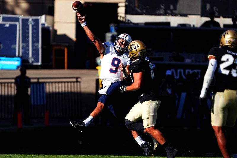 Oct 16, 2021; Boulder, Colorado, USA; Arizona Wildcats quarterback Gunner Cruz (9) throws the ball under pressure from Colorado Buffaloes linebacker Quinn Perry (12) in the third quarter at Folsom Field. Mandatory Credit: Ron Chenoy-USA TODAY Sports