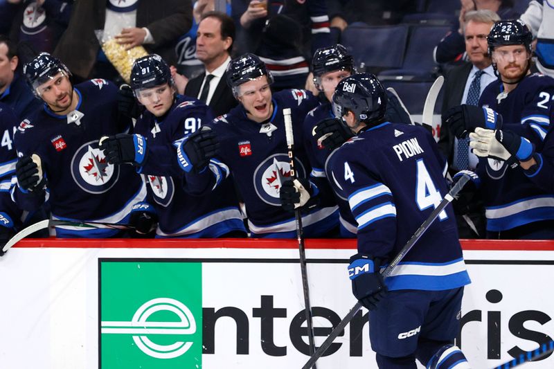 Jan 2, 2024; Winnipeg, Manitoba, CAN; Winnipeg Jets defenseman Neal Pionk (4) celebrates his second period goal against the Tampa Bay Lightning at Canada Life Centre. Mandatory Credit: James Carey Lauder-USA TODAY Sports