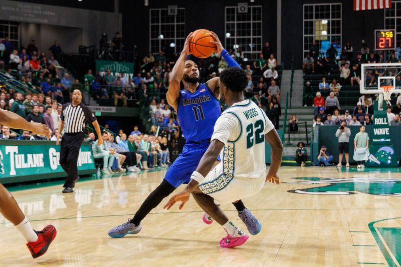 Jan 30, 2025; New Orleans, Louisiana, USA;  Memphis Tigers guard Tyrese Hunter (11) fouls Tulane Green Wave guard Asher Woods (22) during the first half at Avron B. Fogelman Arena in Devlin Fieldhouse. Mandatory Credit: Stephen Lew-Imagn Images