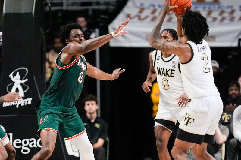 Jan 7, 2026; Winston-Salem, North Carolina, USA; Miami (FL) Hurricanes center Ernest Udeh Jr. (8) defends against Wake Forest Demon Deacons forward Juke Harris (2) during the second half at Lawrence Joel Veterans Memorial Coliseum. Mandatory Credit: Jim Dedmon-Imagn Images