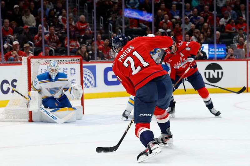 Nov 5, 2025; Washington, District of Columbia, USA; Washington Capitals center Aliaksei Protas (21) shoots the puck on St. Louis Blues goaltender Jordan Binnington (50) during the first period at Capital One Arena. Mandatory Credit: Geoff Burke-Imagn Images