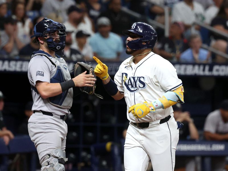 Jul 9, 2024; St. Petersburg, Florida, USA;  Tampa Bay Rays third base Isaac Paredes (17) runs home after he hit a threenrun home run and New York Yankees catcher Austin Wells (28) looks on during the first inning at Tropicana Field. Mandatory Credit: Kim Klement Neitzel-USA TODAY Sports