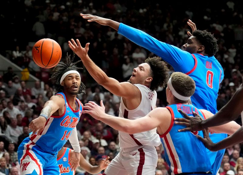 Jan 14, 2025; Tuscaloosa, AL, USA; Alabama guard Mark Sears (1) attempts a shot in the lane defended by Ole Miss guard Dre Davis (14) and Ole Miss forward Malik Dia (0) at Coleman Coliseum. Ole Miss defeated Alabama 74-64. Mandatory Credit: Gary Cosby Jr./USA TODAY Network via Imagn Images