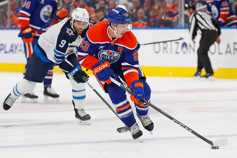 Oct 9, 2024; Edmonton, Alberta, CAN; Edmonton Oilers forward Ryan Nugent-Hopkins (93) looks to make a play in front of Winnipeg Jets forward Alex Iafallo (9) during the first period at Rogers Place. Mandatory Credit: Perry Nelson-Imagn Images